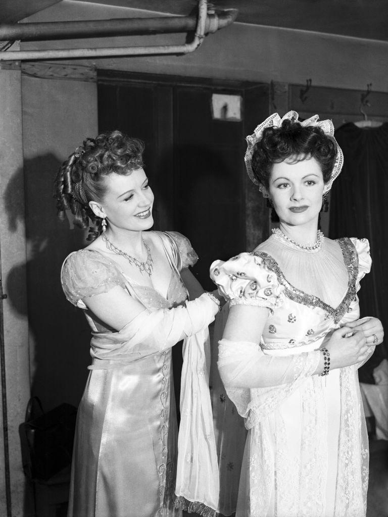 #32 Phyllis Calvert and Margaret Lockwood putting finishing touches to their costumes before re-enacting their roles in “Man in Grey”.