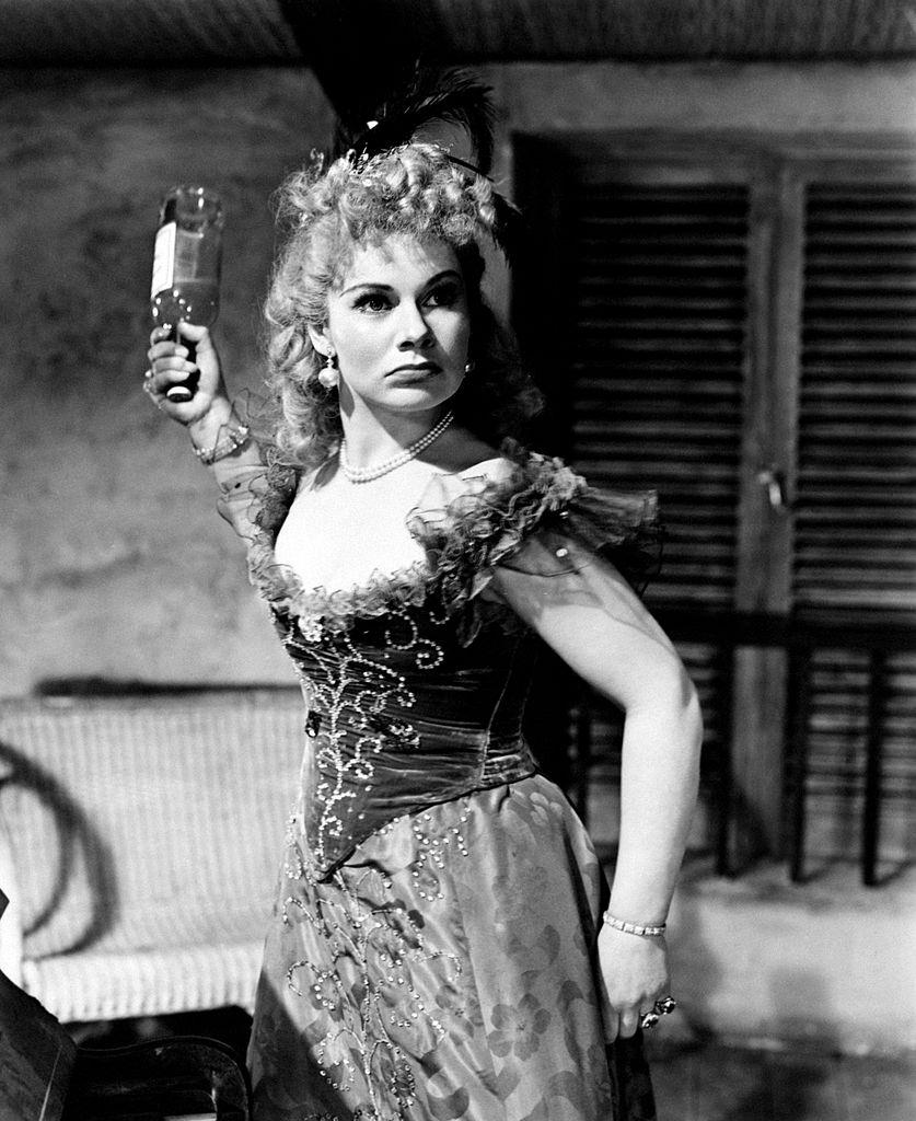 #54 Margaret Lockwood threatening someone with a bottle in the film Laughing Anne, 1948.