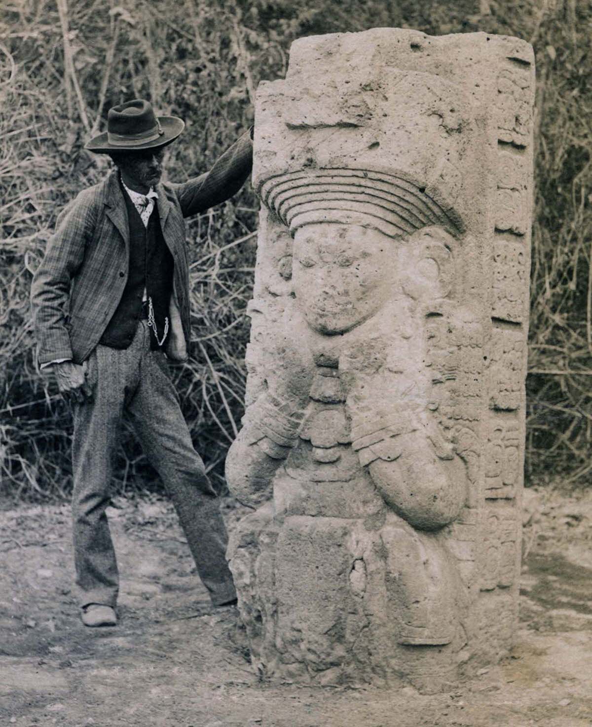 #15 Stela 1 at Copan, Honduras, as found by Alfred P. Maudslay, 1880s. A Honduran man stands next to the stela for scale.