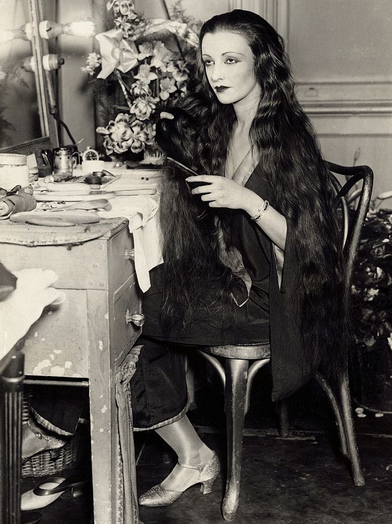 #18 Natacha Rambova combing her long black tresses during an interview, 1927.