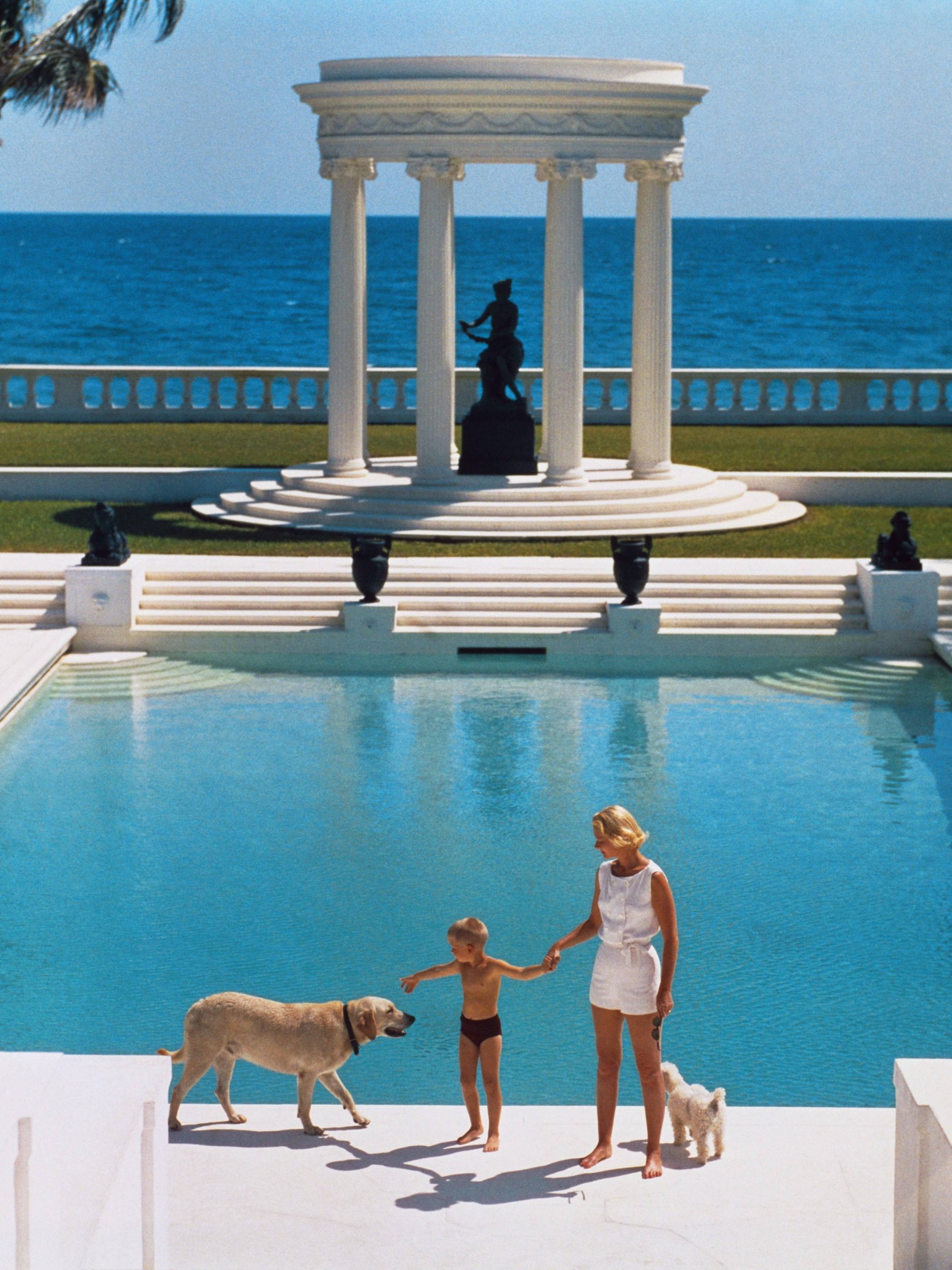 #3 American writer C.Z. Guest and her son Alexander Michael Douglas Dudley Guest in front of their Grecian temple pool on the ocean-front estate, Villa Artemis, Palm Beach.