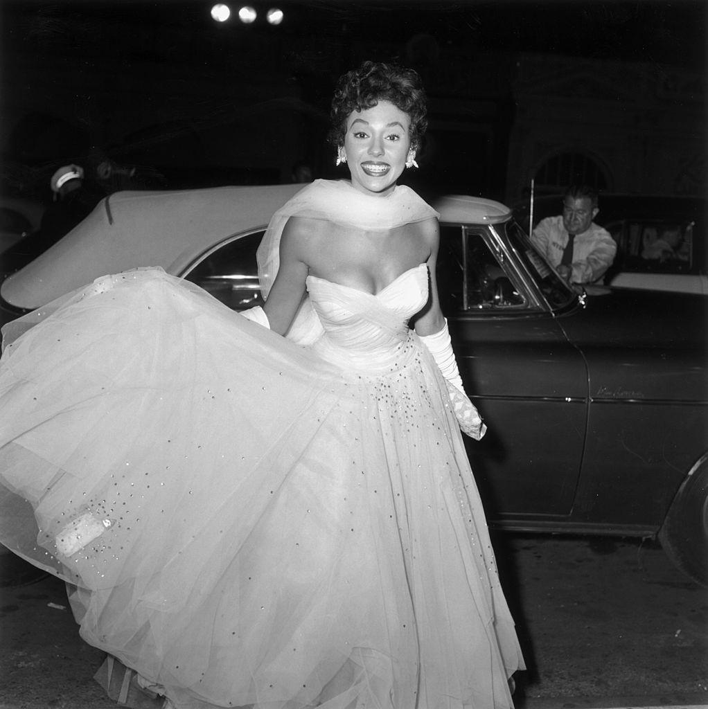 #2 Rita Moreno warnig a white evening gown and arriving at the premiere of director Charles Walters’ film ‘Lili’, 1953.