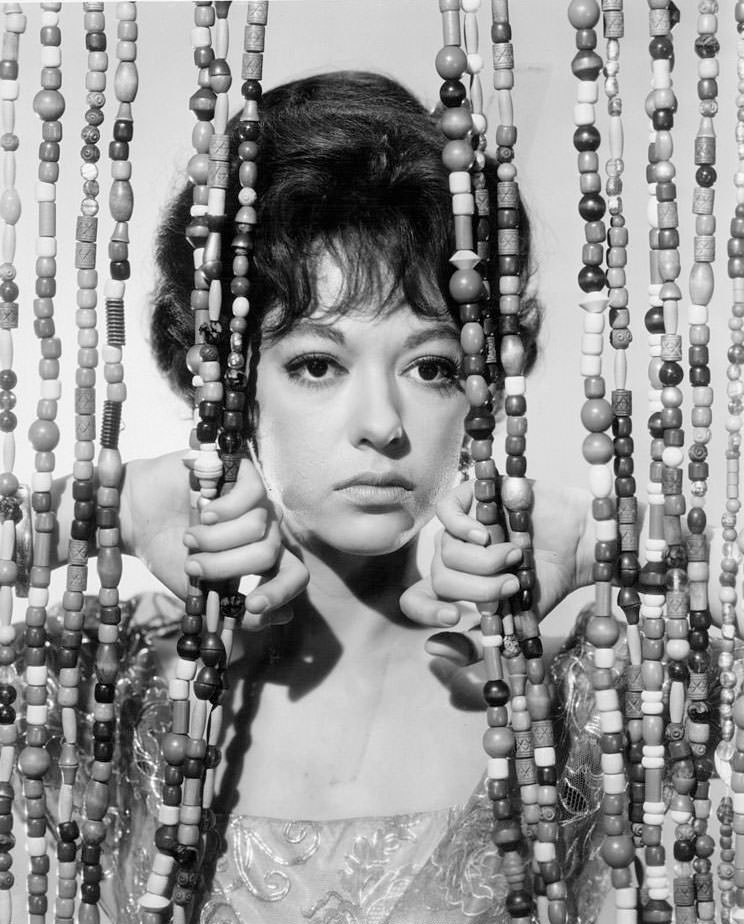 #51 Rita Moreno behind a beaded curtain in a scene from the film ‘A Summer And Smoke’, 1961.