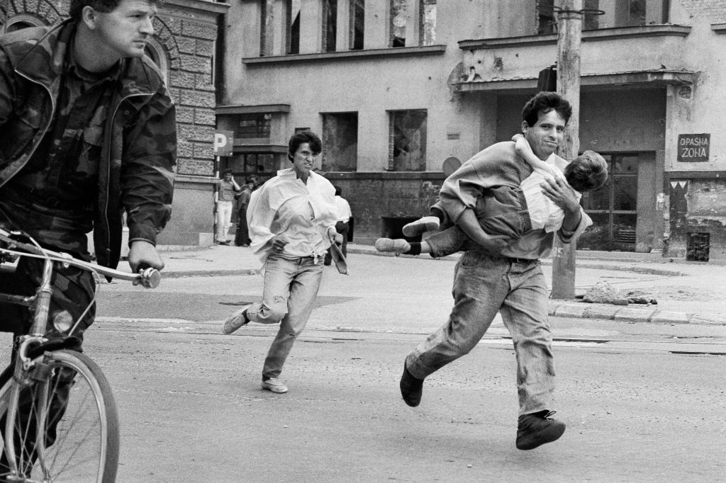 A family dash across ‘Sniper Alley’ to avoid gunfire during the siege of Sarajevo in 1994.