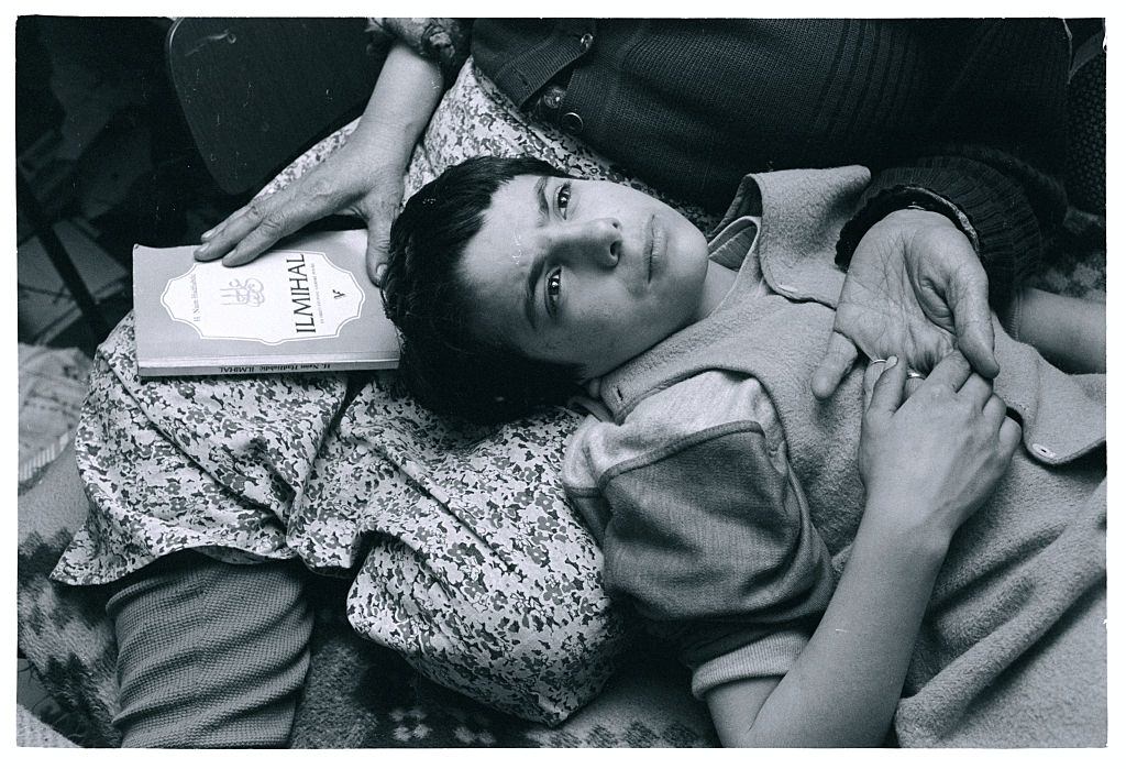 Mirza Mangajic, a 10-year-old Muslim boy, lays his head in his grandmother’s lap as he prays with her.