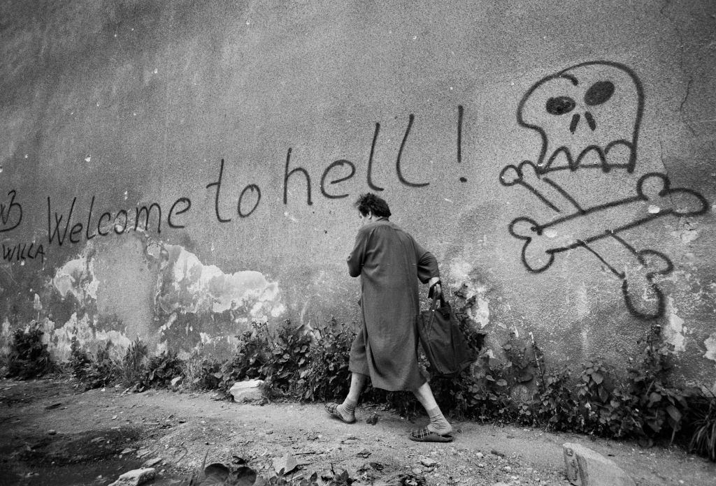 Welcome to hell – a woman hurried past graffiti in the area known as ‘Sniper Alley’ in Sarajevo’s main thorough fare during the siege in 1992.