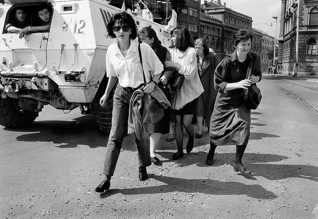 Women shelter behind a UN armoured personnel carrier as they cross ‘Sniper Alley’ during the siege of Sarajevo in 1995.
