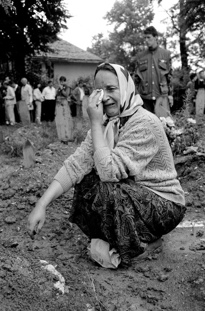 A woman grieves at her relative’s grave after his burial in a Sarajevo cemetery, 1994.