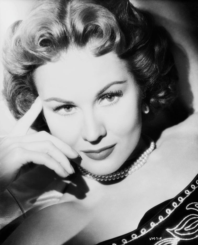 Virginia Mayo wearing a beaded top and pearl necklace, 1955.