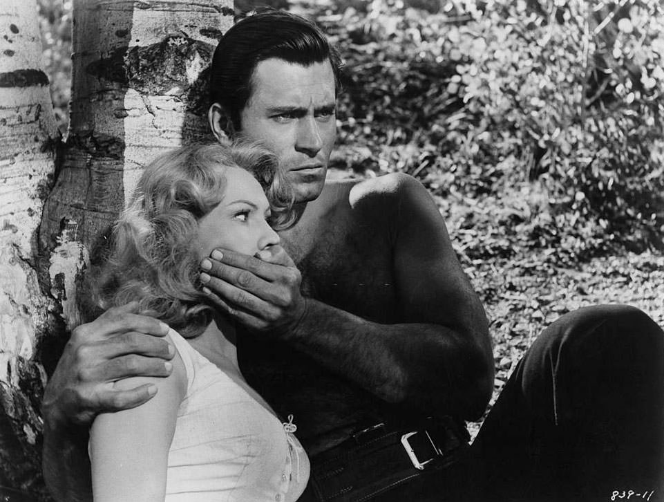 #22 Virginia Mayo’s mouth is held shut by Clint Walker in a scene from the film ‘Fort Dobbs’, 1958.