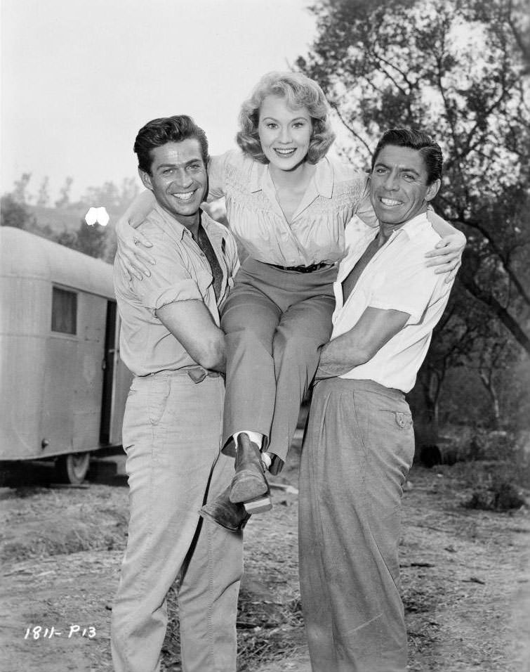 #46 George Nader holds up Virginia Mayo with Michael Pate on set of the film ‘Congo Crossing’, 1956.