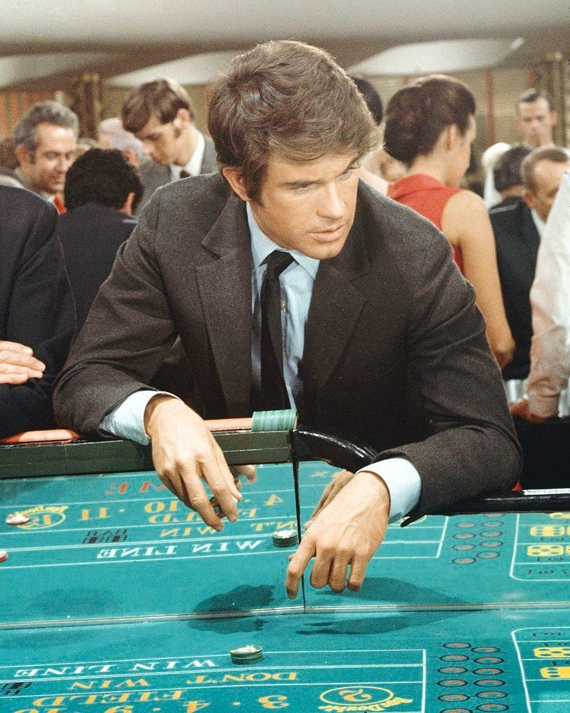 #44 Warren Beatty leaning over a craps table in a publicity still issued for the film, ‘Kaleidoscope’, 1966.