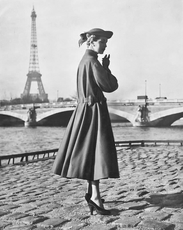 #12 Joan Olson in loose coat of geranium-red wool, the below-the-waist belt gathers the back pleats, by Jacques Fath, 1953