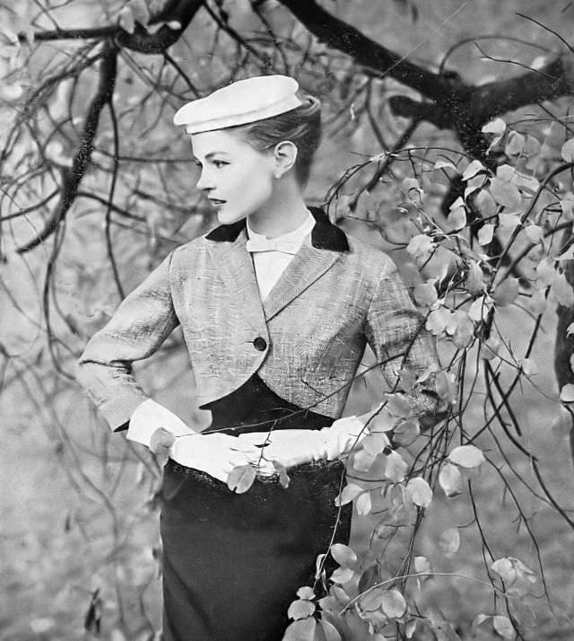 #31 Joan Olson in black-and-white herringbone tweed short chesterfield jacket with black velvet collar and lined in red satin by Hayette, 1957.