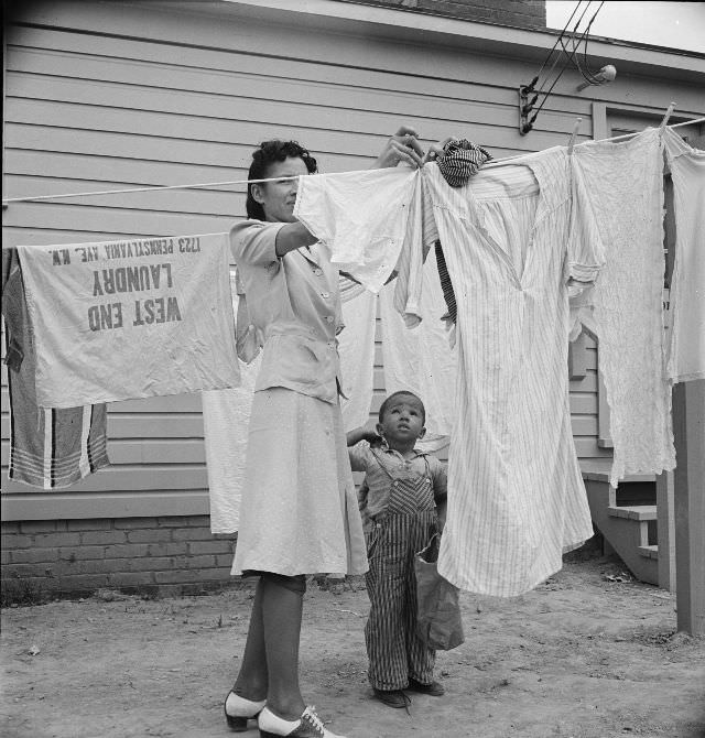 #2 A woman hanging out washing with her young son in front of the community building in a FSA (Farm Security Administration) housing relief camp for African Americans, Arlington, Virginia, 1942