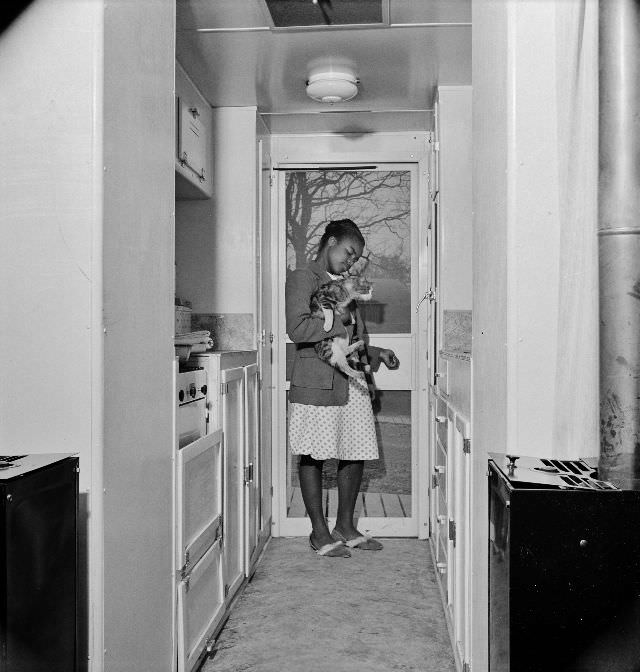 #42 Young girl with her cat in the kitchen of her home,Arlington, Virginia, April 1942