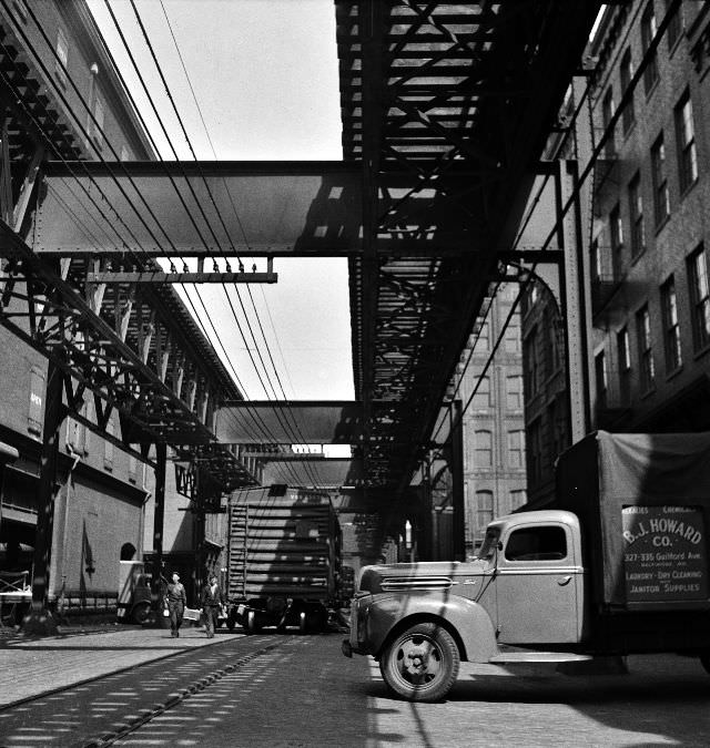 #48 Trucks and trains unloading goods underneath an elevated trolley, Baltimore, Maryland, April 1943