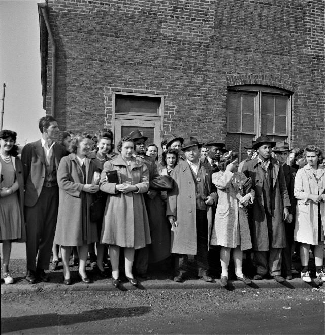#50 Workers waiting for a bus home at a busy intersection at four in the afternoon, Baltimore, Maryland, April 1943
