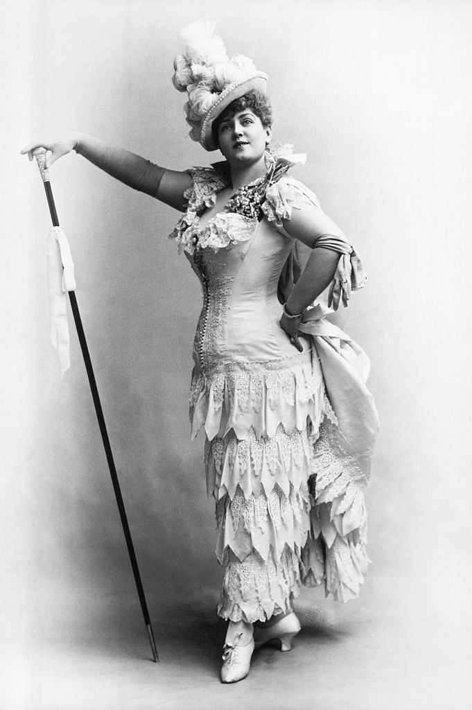 #9 Lillian Russell in one of her typical poses. She is shown full-length, wearing a flounced white dress and plumed hat, 1890.