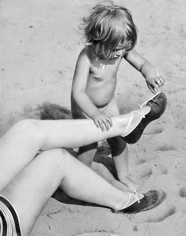 #5 Summer on the beach. A little girl opened the laces of her mother’s slippers, 1929