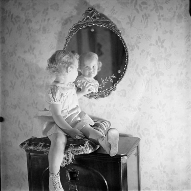 #5 A girl sitting on pillow looking into mirror