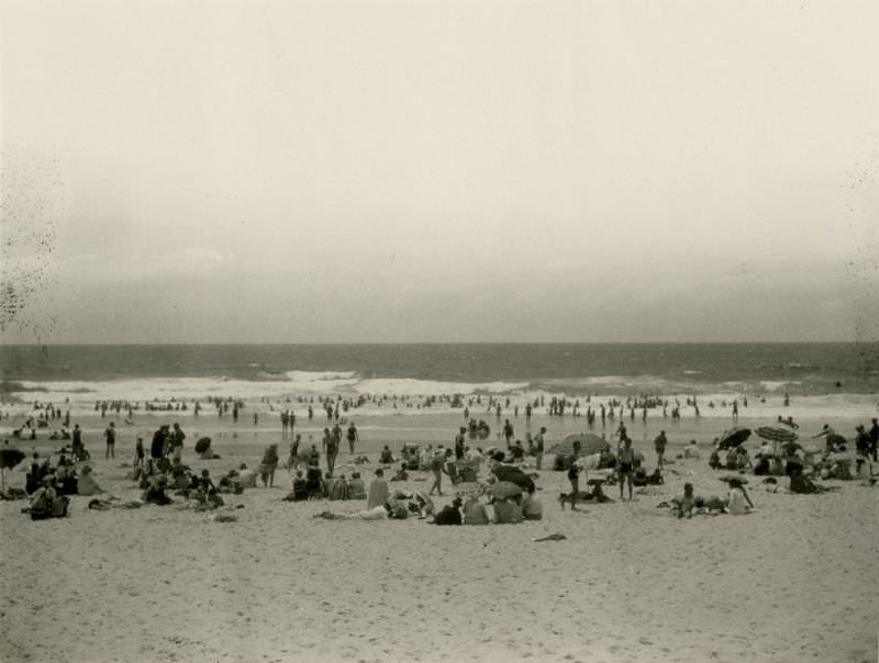 #39 Locals and tourists sun bathing and surfing at Main Beach in Southport, 1930s