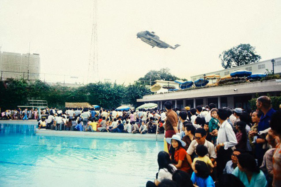 #43 Crowds of Vietnamese and Western evacuees wait around the swimming pool inside the American Embassy compound in Saigon hoping to escape Vietnam via helicopter before the arrival of North Vietnamese troops.