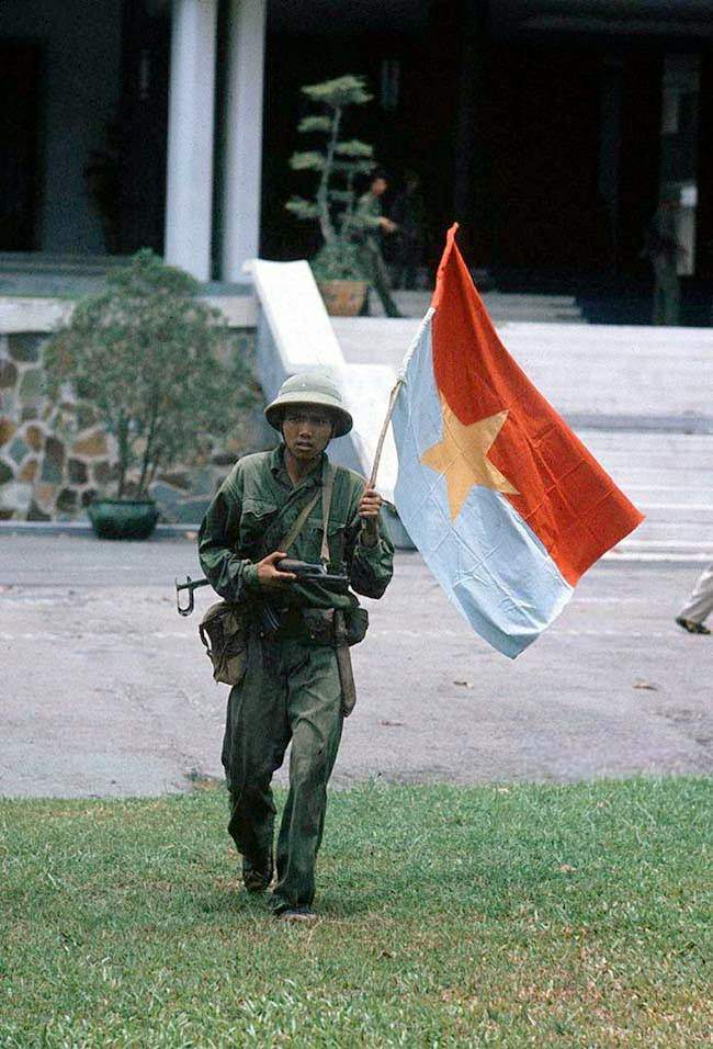 Taken of the presidential palace. North – Vietnamese officer holding a flag of the G.R.P. April 30, 1975.