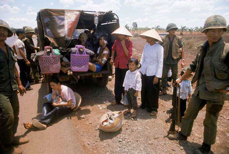 #59 South Vietnamese citizens seeking to flee the country April 1975 are assisted by South Vietnamese troops.