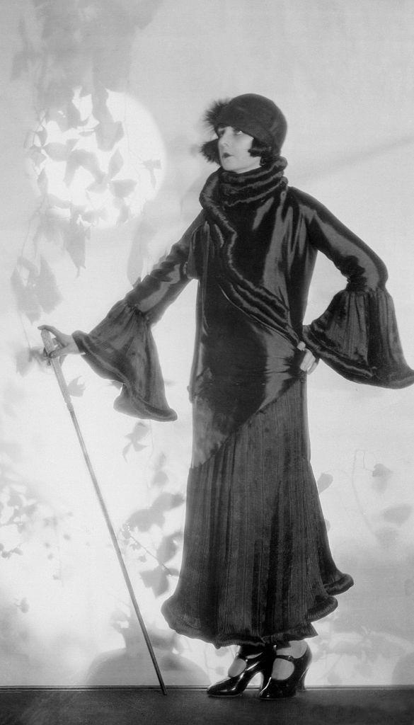 #14 Alice Terry models an imported coat of satin faced canton with a deep flounce skirt, bell cuffs and a unique collar, Hollywood, California, 1924.