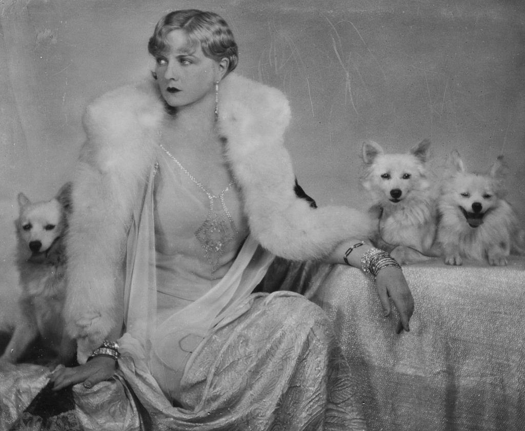 #18 Alice Terry wearing a fur coat with her pet dogs, 1925.
