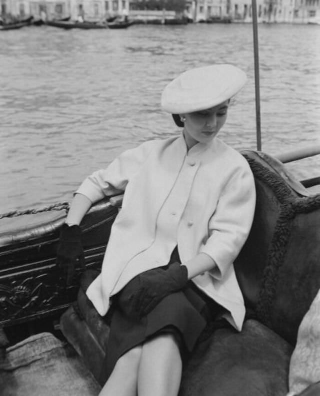 #15 Alla in Christian Dior’s loose-fitting jacket with mandarin-collar sits in a gondola, Venice, June 1951