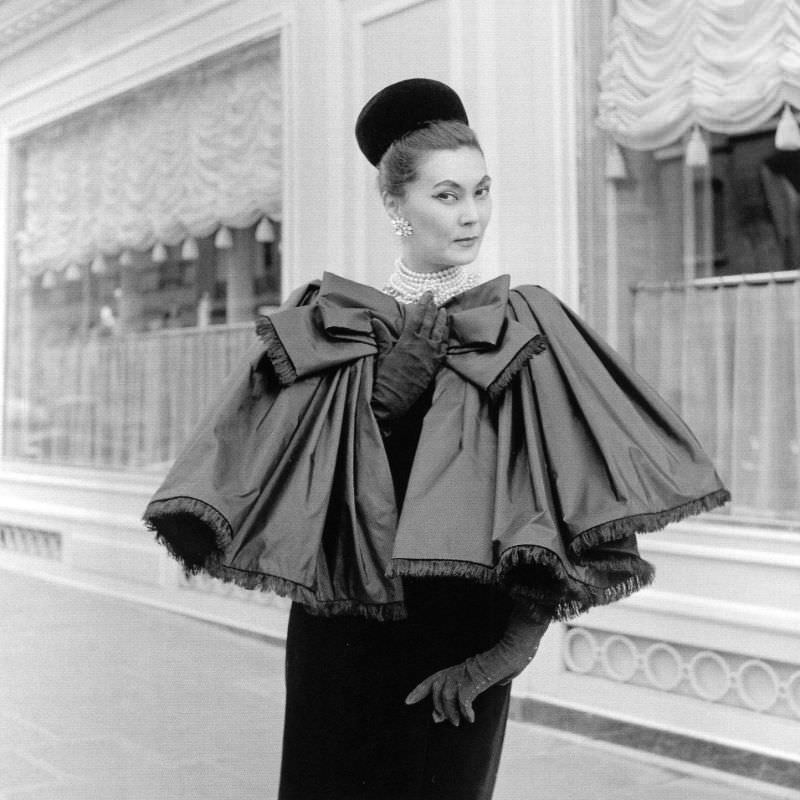 #34 Alla in fringed satin capelet tied in large bow worn over slim velvet dress by Yves Saint Laurent, photo by Willy Maywald, Paris, 1959