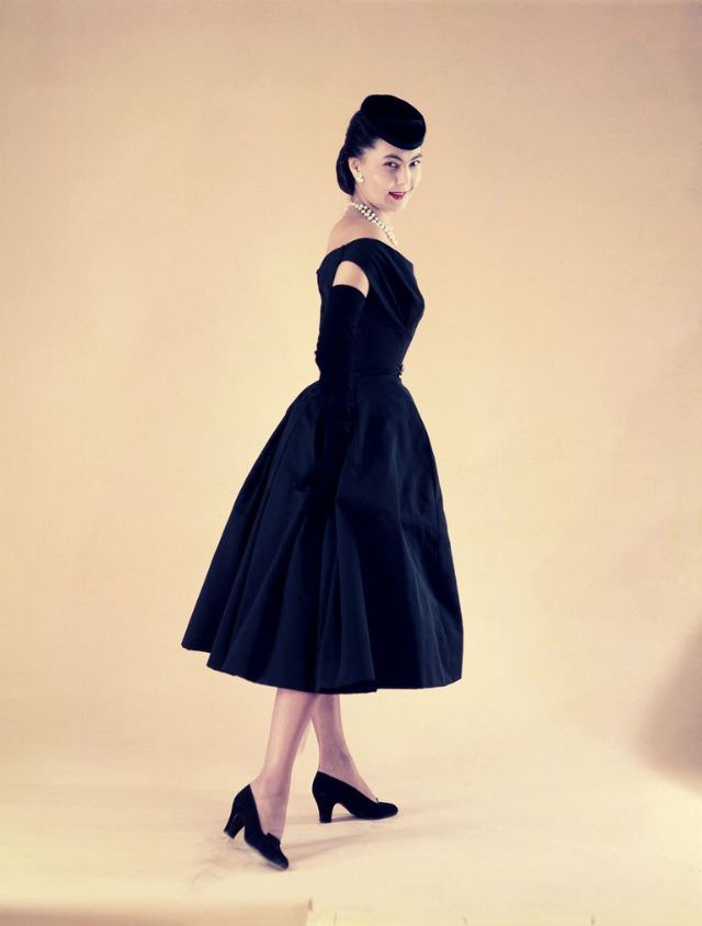 #36 Alla in Christian Dior’s midnight blue taffeta dress with draped bodice worn with a small velvet cap tilted forward, Paris, circa 1950s