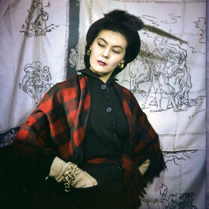 #6 Alla in dress and shawl by Battilocchi stands in front of scarves printed with designs by Giorgio de Chirico, 1949