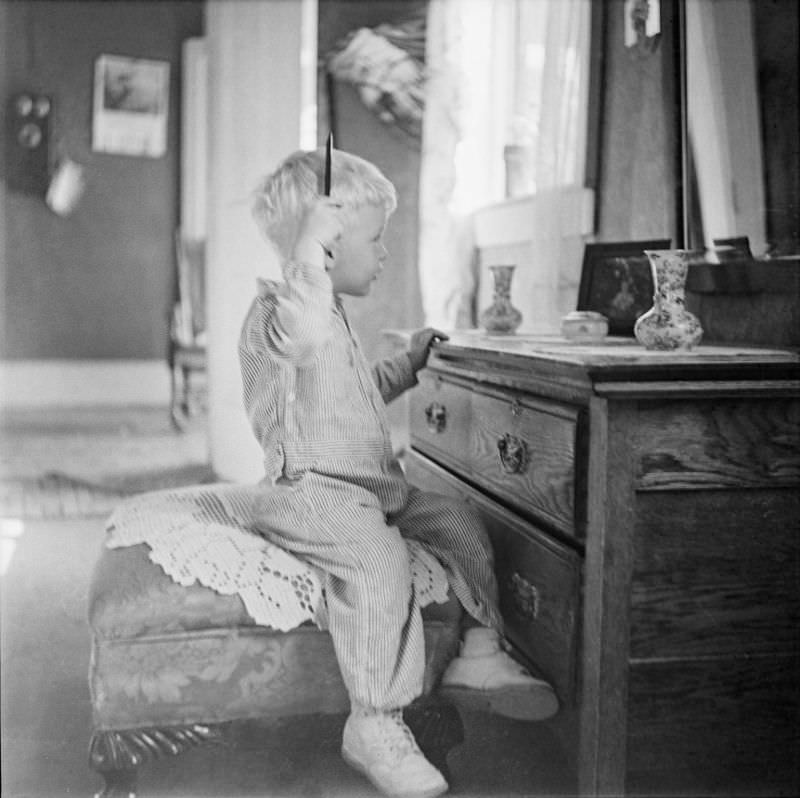 #11 Boy sitting in front of a mirror, holding a comb