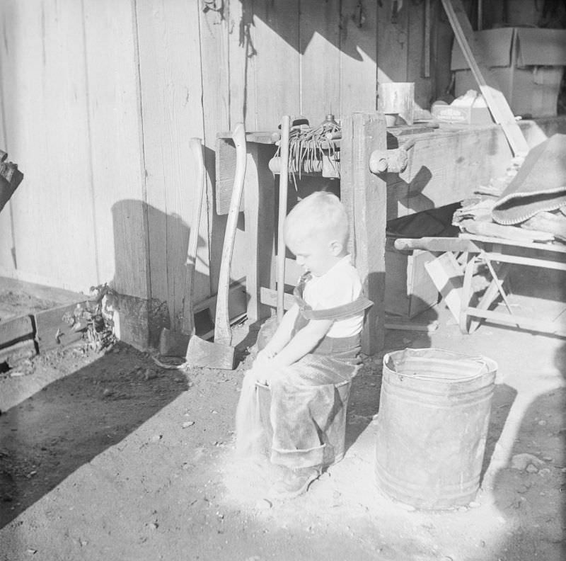 #12 Boy sitting on a pale in front of a workbench