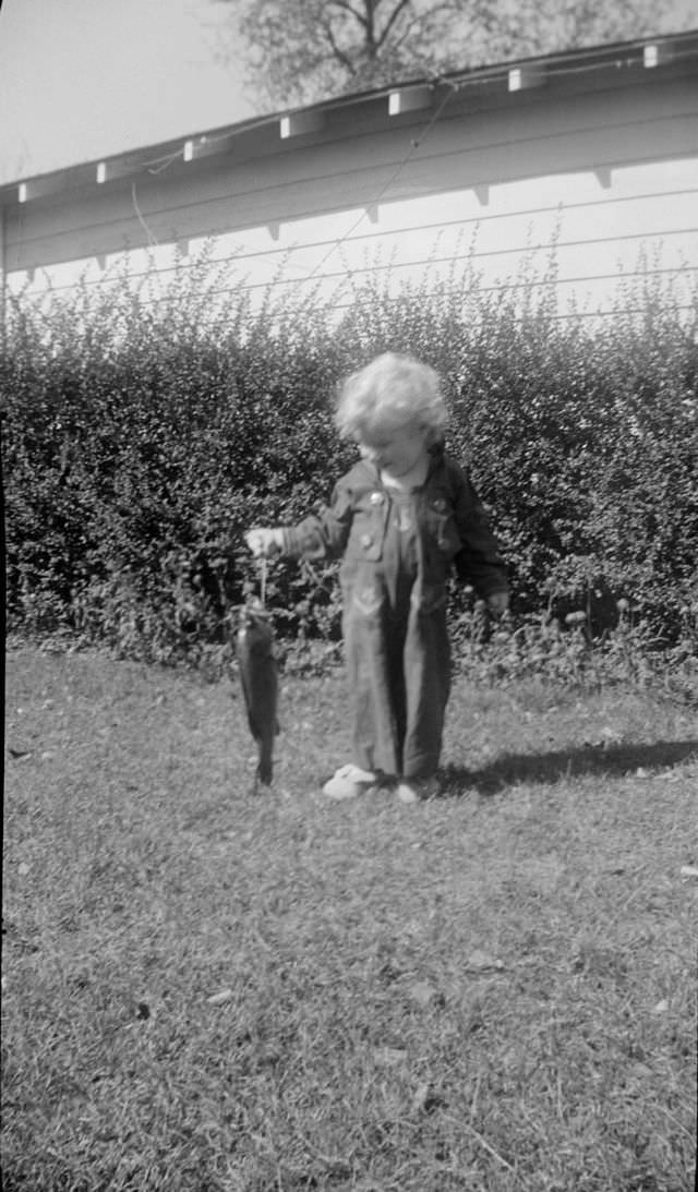#22 Child holding a fish outside