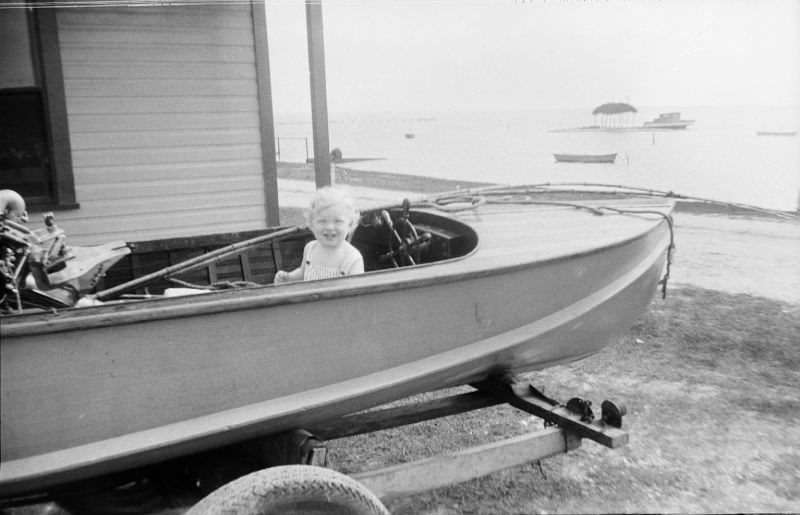 #33 Smiling girl sitting in a boat on a trailer