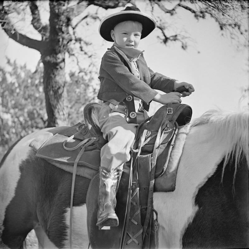 #9 Boy sitting in a saddle, on top of a horse