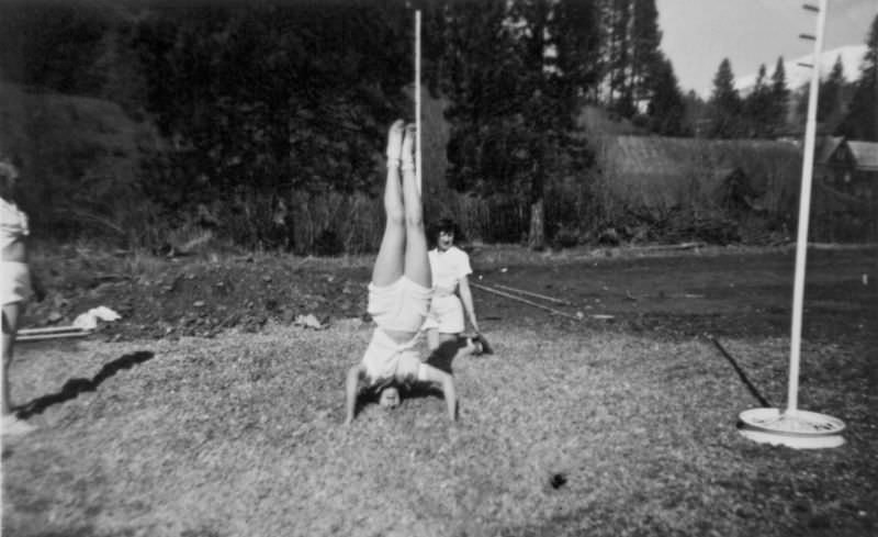 #2 A teenage girl performs a headstand while a couple other watch
