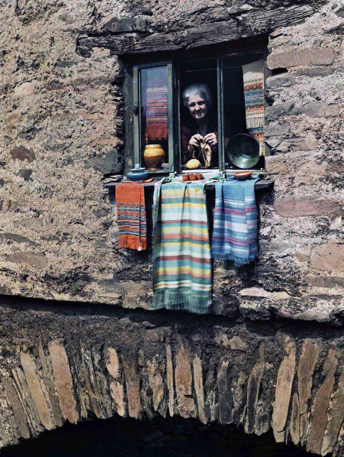 #10 A woman sticks her head out of her bridge house window, in Ambleside, Lake District, Cumbria, England.