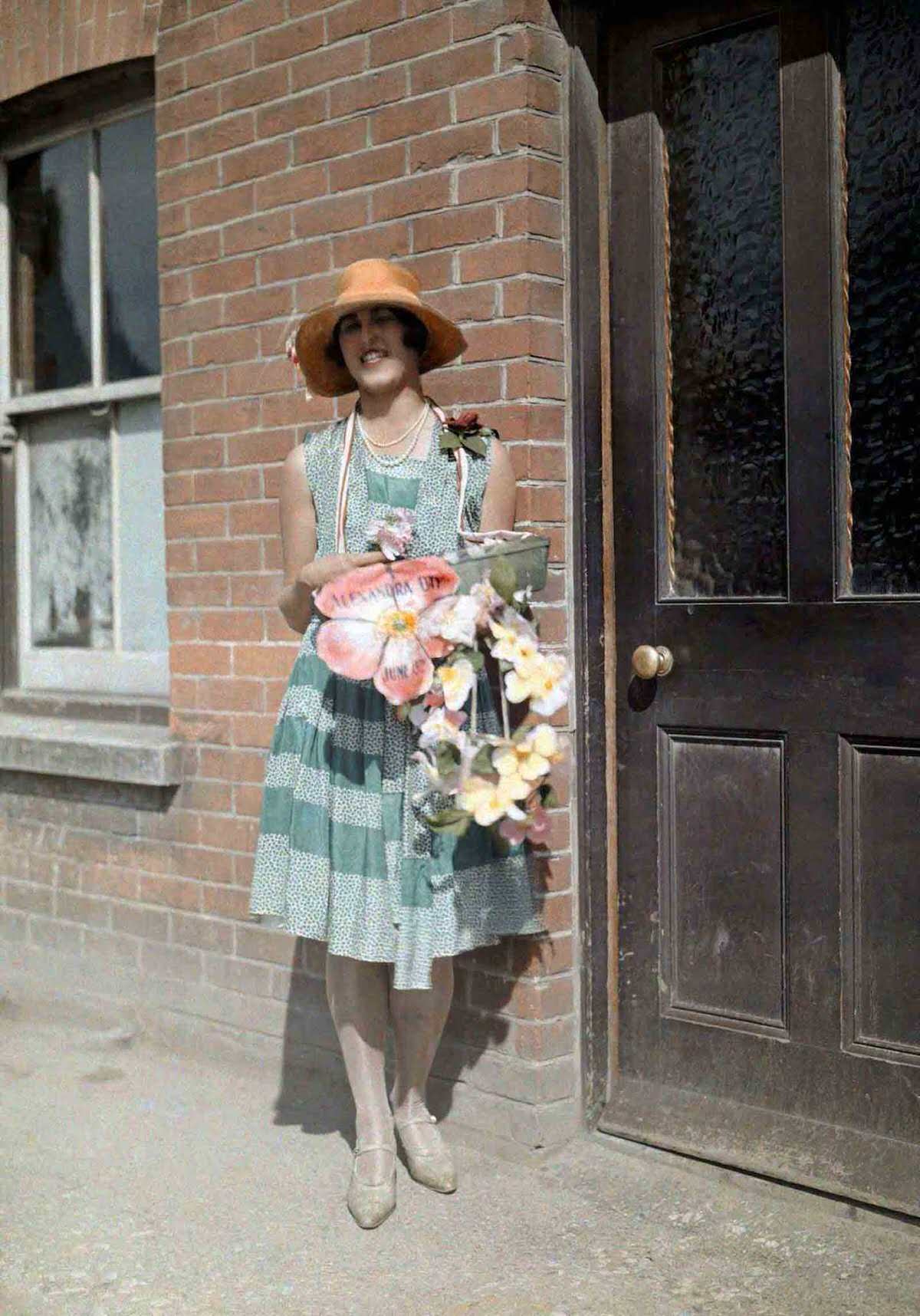 #12 A young girl sells artificial flowers for charity on Alexandra Day, in Kent.