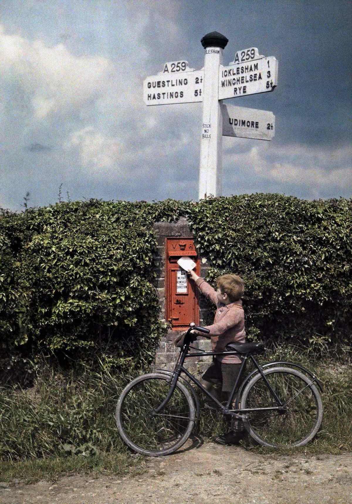 #18 A little boy mails a letter in the hedgerow, in Sussex.