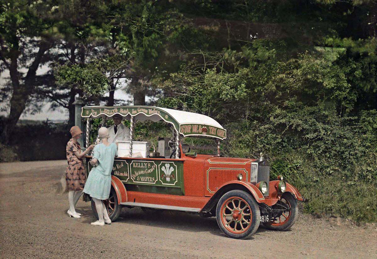 #9 Two women buy ice cream from a vendor out of his converted car, in Cornwall. Kelly’s ice cream is still in production today.