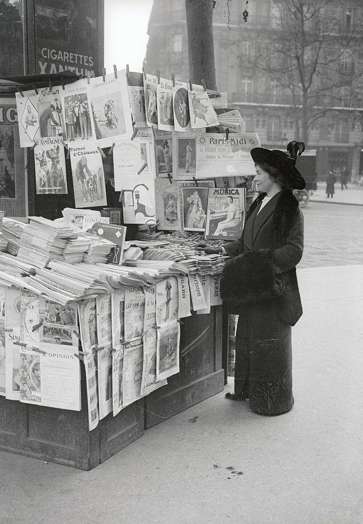 #18 Christobal Pankhurst, daughter of Emmeline Pankhurst, standing at Newsstand, 1901.