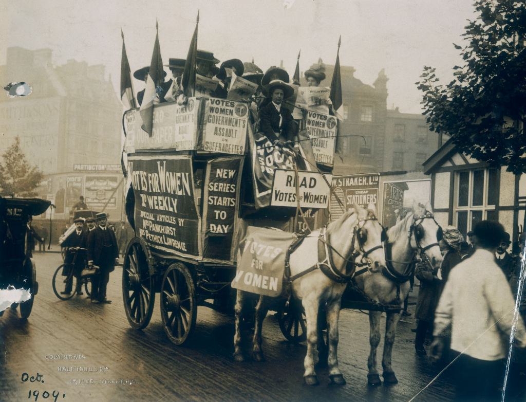 #36 A group of suffragettes on board a cart advertising the newspaper Votes for Women, containing articles by Emmeline Pankhurst.