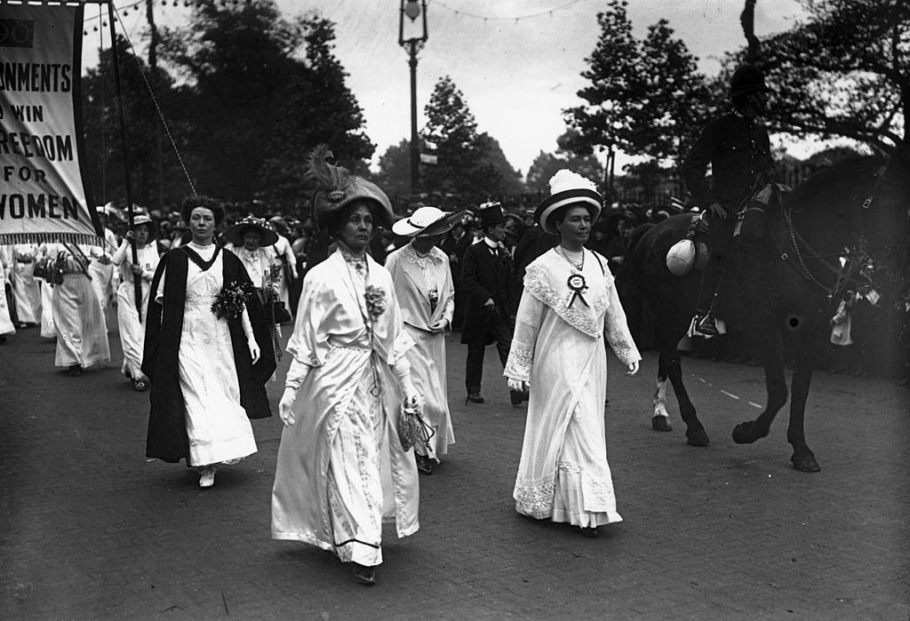 #45 Emmeline Pankhurst leads a suffragette parade through London, with the protesters all dressed in white.