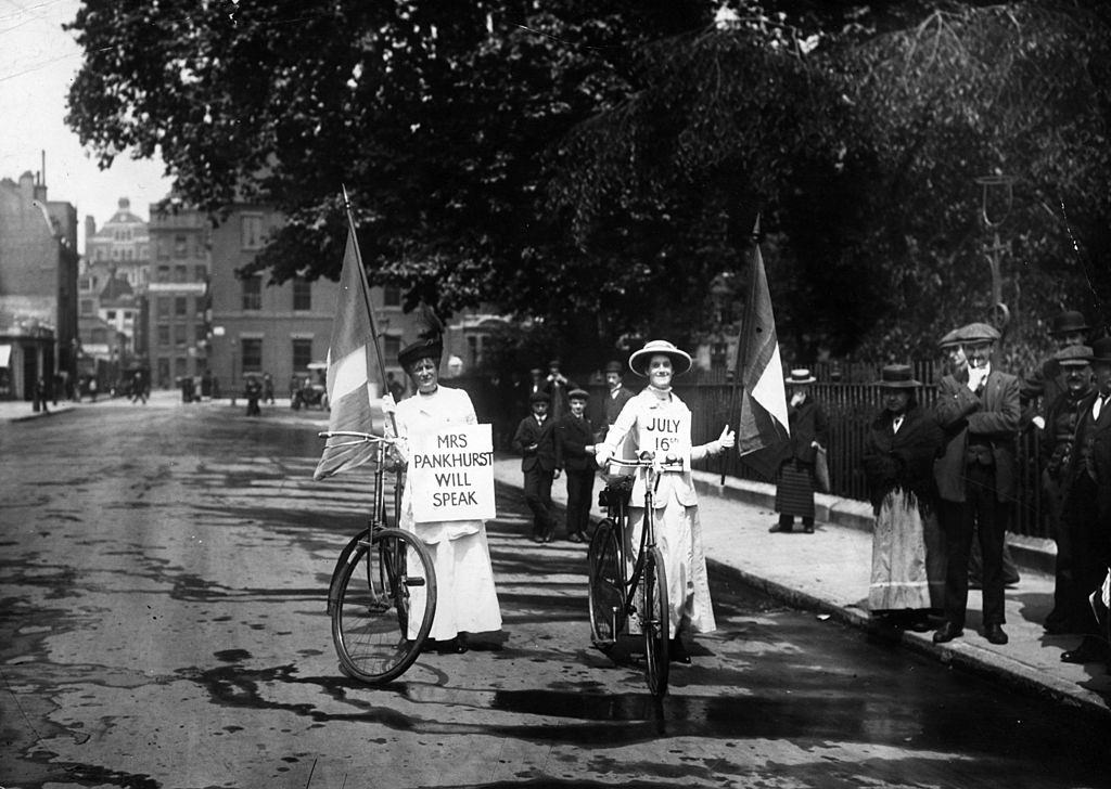 #55 Two suffragettes advertising a meeting at which Emmeline Pankhurst will speak, 1914.