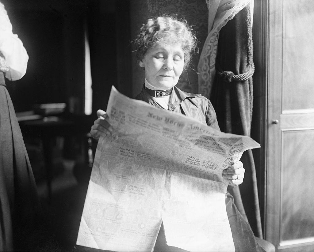 #61 Emmeline Pankhurst Reading the New York American in Manhattan Hotel Apt, 1916.